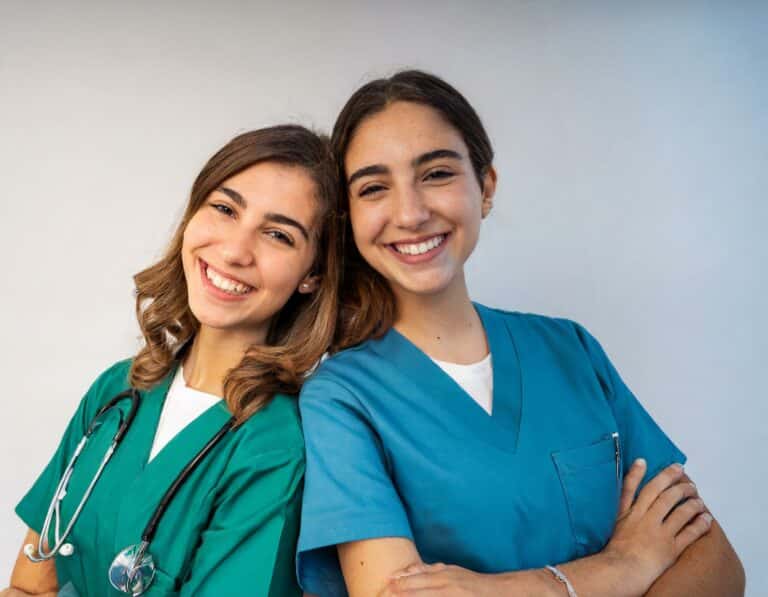 Firefly 2 caucasian nurses, with brown hair, one with blue uniform and one with green, leaning again